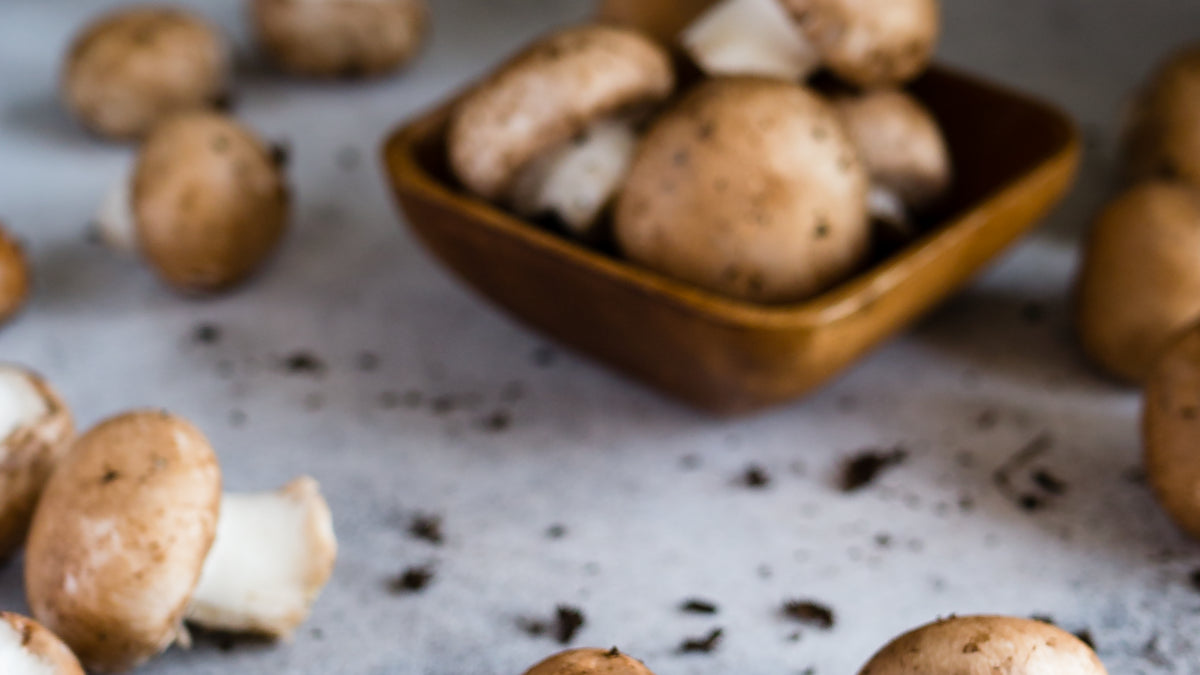 Fresh brown mushrooms arranged on a neutral surface for a functional mushroom supplement label guide