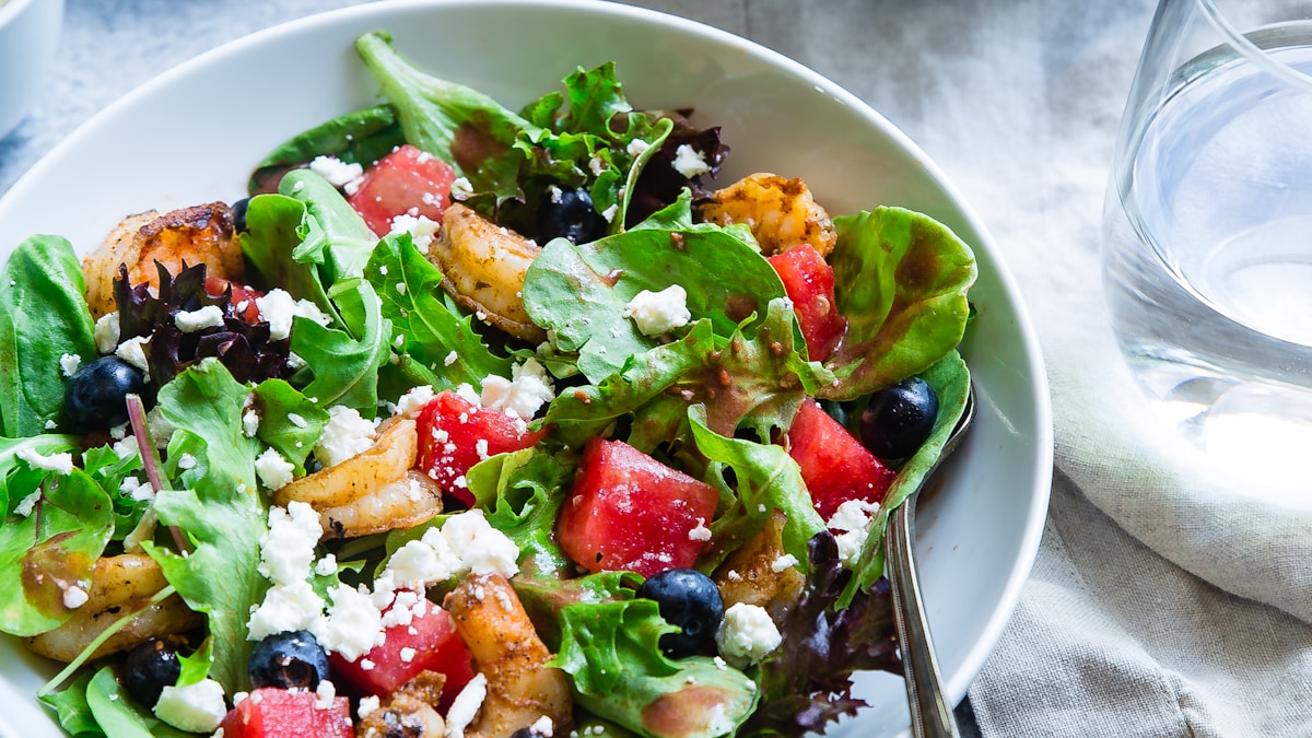 Colorful fresh produce arranged on a bright table for a gentle seasonal wellness routine refresh